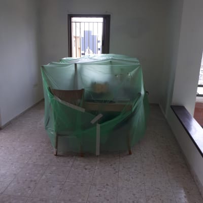 רהיטים מכוסים בניילון ירוק לקראת צביעה