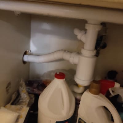 צינור פלסטיק לבן מתחת לכיור עם חיבורים