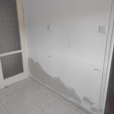 קיר עם תיקוני טיח, מתגי חשמל ודלת זכוכית