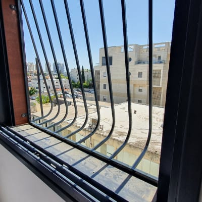 סורגי מתכת על חלון עם מסגרת שחורה