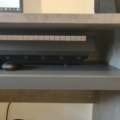 מקלדת על מדף עץ מתחת לשולחן