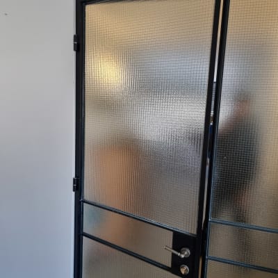 דלת זכוכית מחוספסת עם מסגרת מתכת שחורה