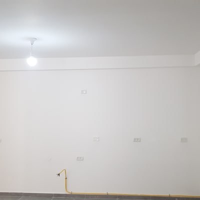 קיר עם שקעים חשמליים ונורה תלויה מהתקרה