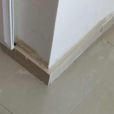 פינת קיר עם תיקוני טיח ורצפה מלוכלכת