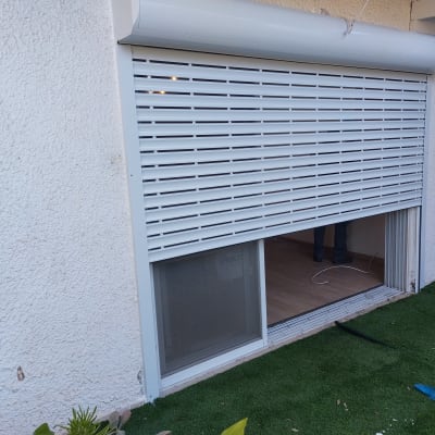 תריס אלומיניום לבן מותקן על חלון