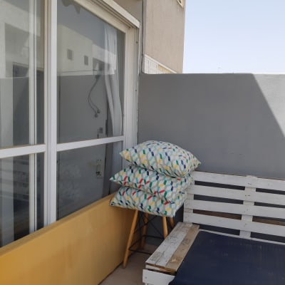 מרפסת עם כריות צבעוניות על כיסא עץ