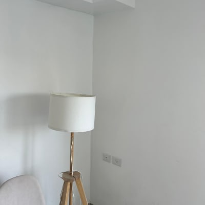 קיר לבן עם מנורת עמידה וכיסא