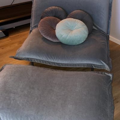 כריות עגולות על כורסה מרופדת אפורה