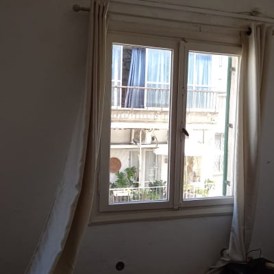 חלון זכוכית עם וילונות לבנים פתוחים