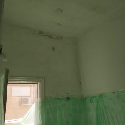 קיר מתקלף עם כיסוי פלסטיק ירוק להגנה על הקירות