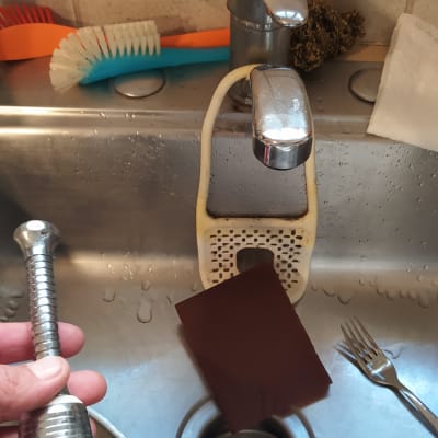 יד מחזיקה חלק ברז בכיור מטבח