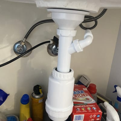 צנרת פלסטיק לבנה מתחת לכיור עם חיבורים