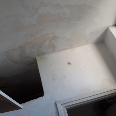 קיר ותקרה עם סימני רטיבות והתקלפות צבע