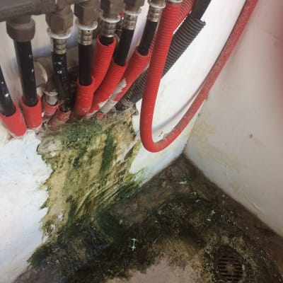 צינורות מים עם נזילה וקורוזיה על הקיר