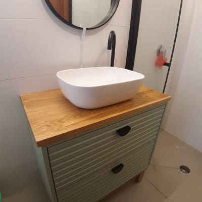 כיור לבן על ארון עץ עם ברז שחור