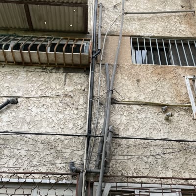 צינורות חשמל ומים על קיר חיצוני של בניין
