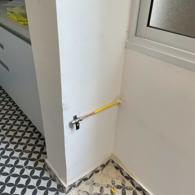 צינור גז צהוב עם ברז סגירה על קיר לבן