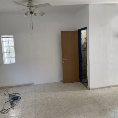 חדר ריק עם מקדחה על הרצפה וסולם בצד