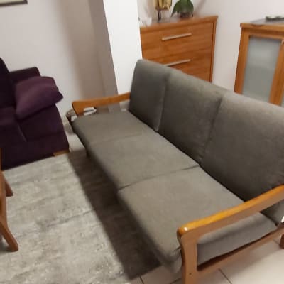 ספה אפורה עם ריפוד מרופד על שטיח אפור