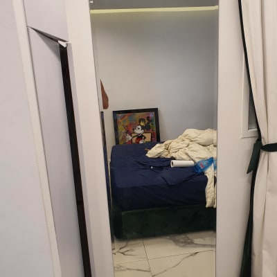 מראה גדולה על קיר לבן בחדר שינה