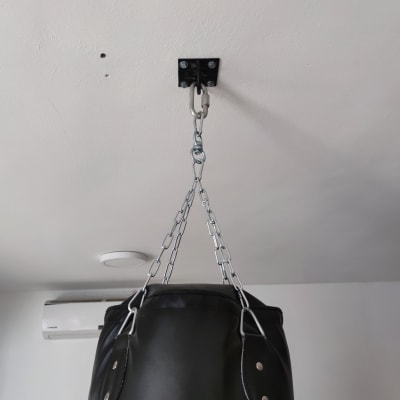 שק אגרוף תלוי מהתקרה עם שרשראות וברגים