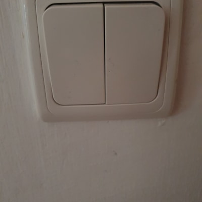 מתג חשמל כפול על קיר לבן