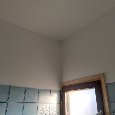 קיר צבוע בלבן מעל אריחים כחולים