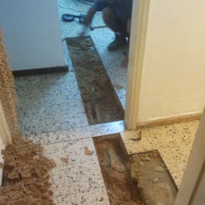 אדם עובד על תיקון צנרת ברצפה