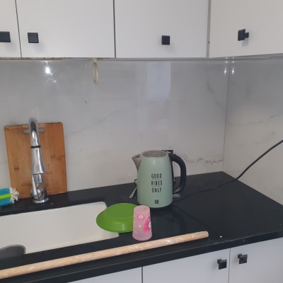 מטבח עם כיור, ברז, קומקום, קרש חיתוך ומברשת