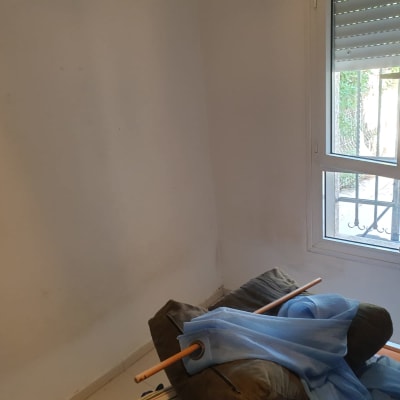 קיר לבן עם סימני לכלוך, רולר צביעה על כורסה