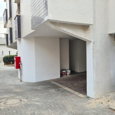 פחיות צבע ומברשות צביעה ליד קיר צבוע