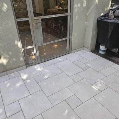 ריצוף חדש בחצר עם דלת זכוכית וציוד מכוסה