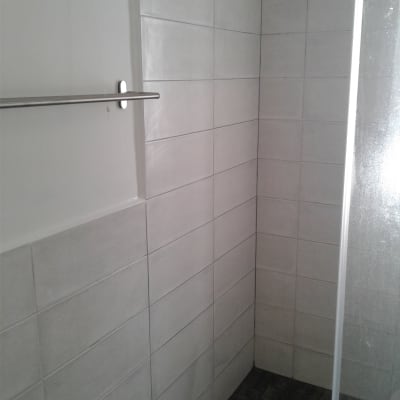 קיר אריחים לבנים עם מוט מתכת