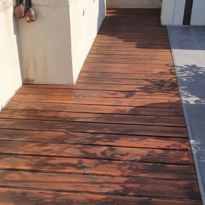 דק עץ חום עם מעקה מתכת על גג