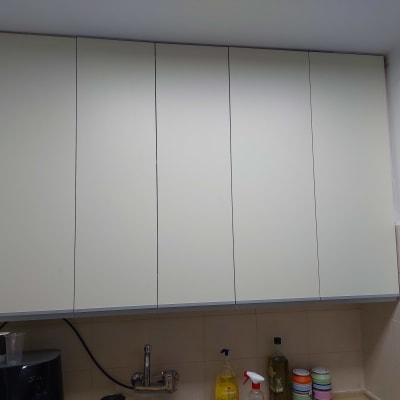 ארונות מטבח לבנים עם מוצרי ניקוי על השיש