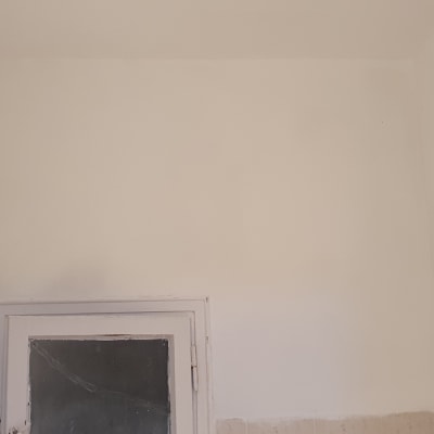 קיר צבוע בלבן עם סימני צבע שונים