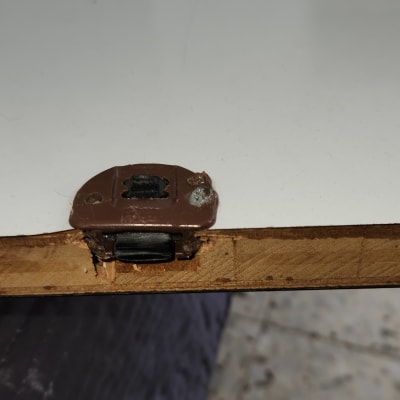 מנעול מתכת חום מותקן על דלת עץ לבנה