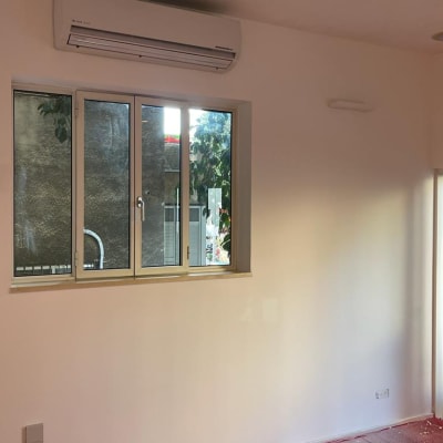 קיר צבוע בלבן עם יריעות מגן אדומות על הרצפה