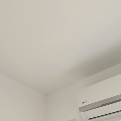 קיר ותקרה צבועים בלבן ליד מזגן