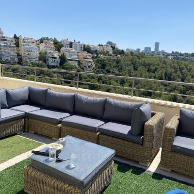 כריות ריפוד אפורות על ספות ראטן במרפסת