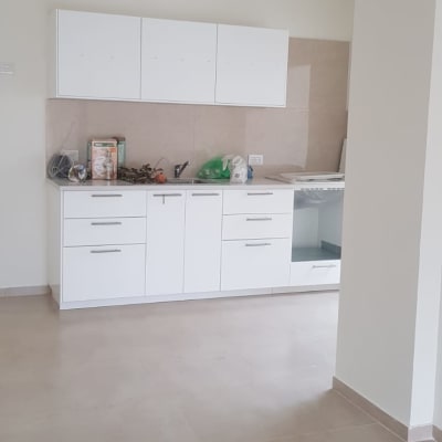 ארונות מטבח לבנים עם משטח עבודה וכיור