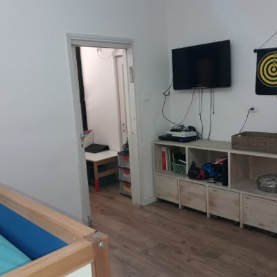 ארון עץ עם מדפים, טלוויזיה תלויה על הקיר