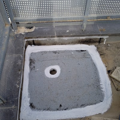 אזור אטום עם חומר איטום לבן סביב פתח ניקוז