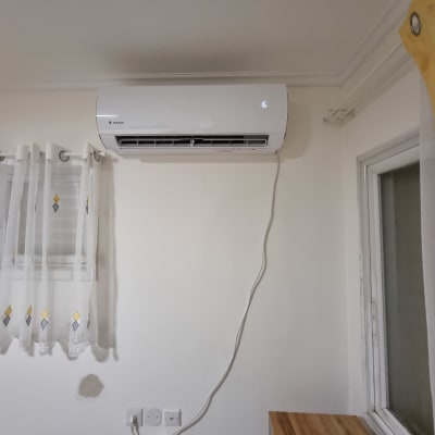 מזגן מותקן על קיר עם כבל חשמל מחובר