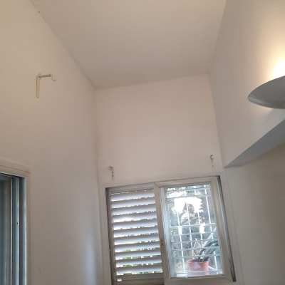 קיר לבן עם חלון ותריסים, תאורה על הקיר