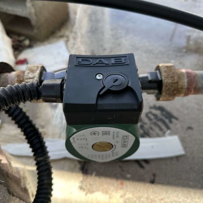 משאבת מים עם חיבורים וצינור שחור