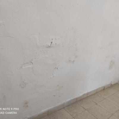 קיר לבן עם סימני שפכטל ותיקונים