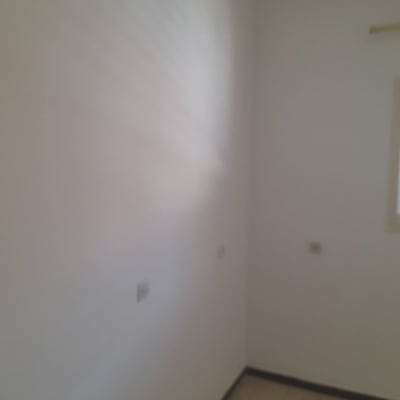 קיר לבן עם חלון קטן בצד ימין