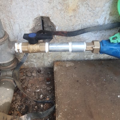 שסתום פליז וצינור מתכת על קיר בטון