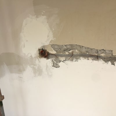 קיר עם חוטי חשמל חשופים ותיבת חיבורים